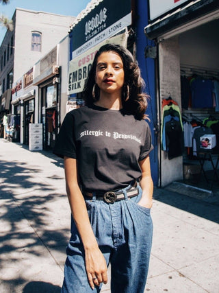 Viva La Bonita Women streetwear black t-shirt. Latina wearing black Allergic to pendejadas t-shirt in Los Angeles. Latina wearing gold hoop earrings.