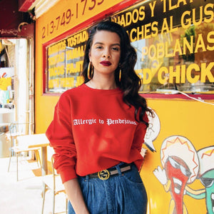 Viva La Bonita women streetwear red Allergic to Pendejadas Sweatshirt.  Latina wearing gold hoops red lipstick. San Fernando Valley photoshoot.